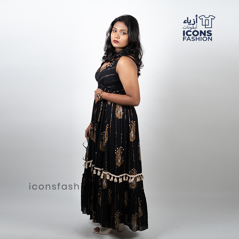 Black-sleeveless-maxi-dress-with-gold-paisley-prints-and-tassel-detailing-near-the-hem
