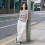 Women-wearing-black-and-white-striped-sleeveless-shirt-with-round-neck